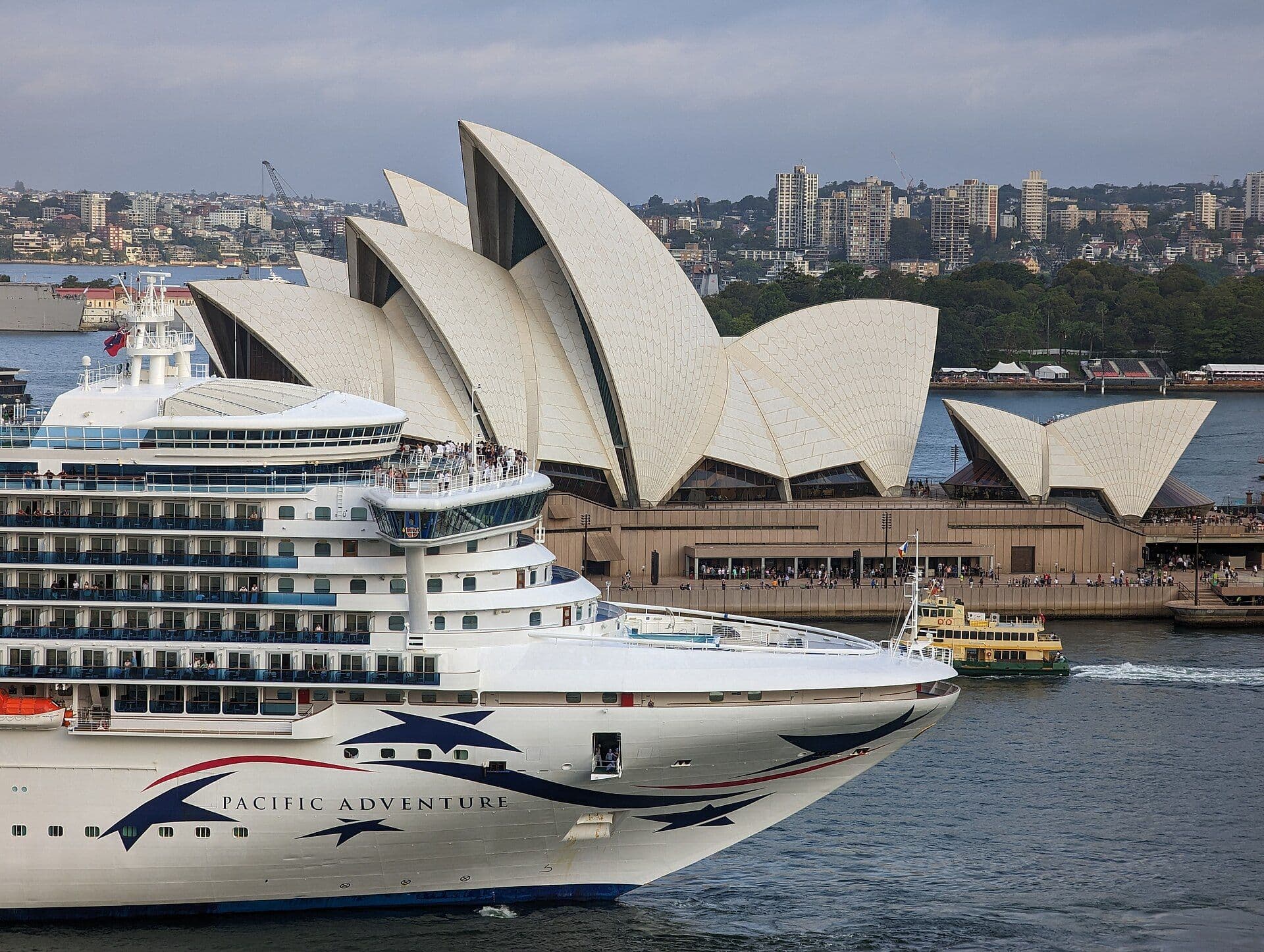 A cruise ship departing Sydney Harbour past the Opera House